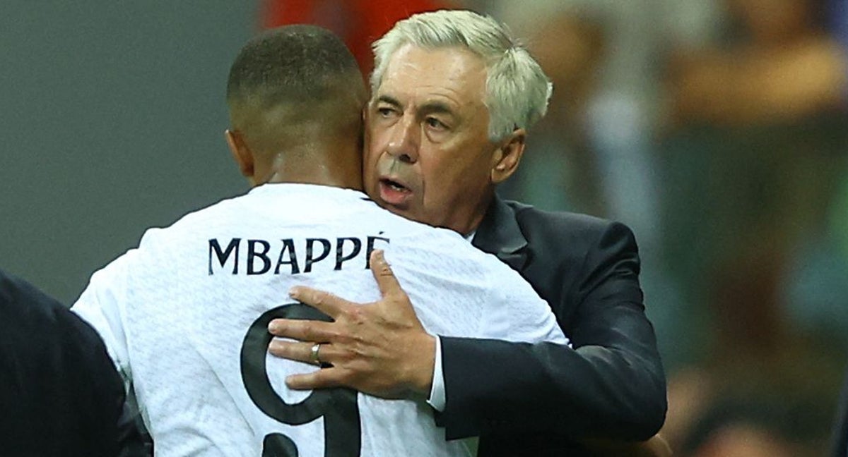 Ancelotti abraza a Mbappé en Varsovia.