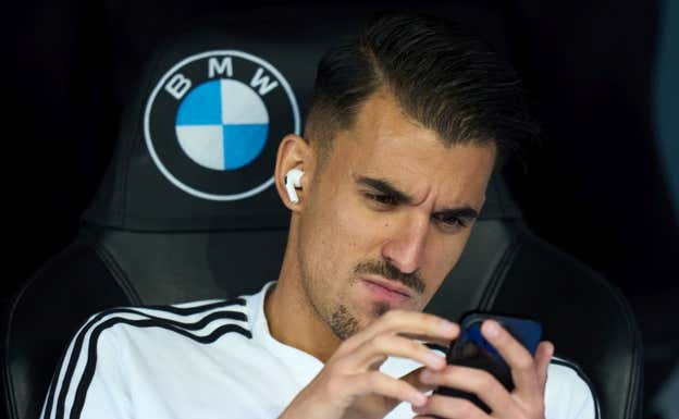 Dani Ceballos, en el banquillo, consultando su teléfono.  GETTY