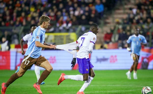 Charles de Ketelaere agarra de la camiseta a Ousmane Dembélé en una acción del partido. EFE
