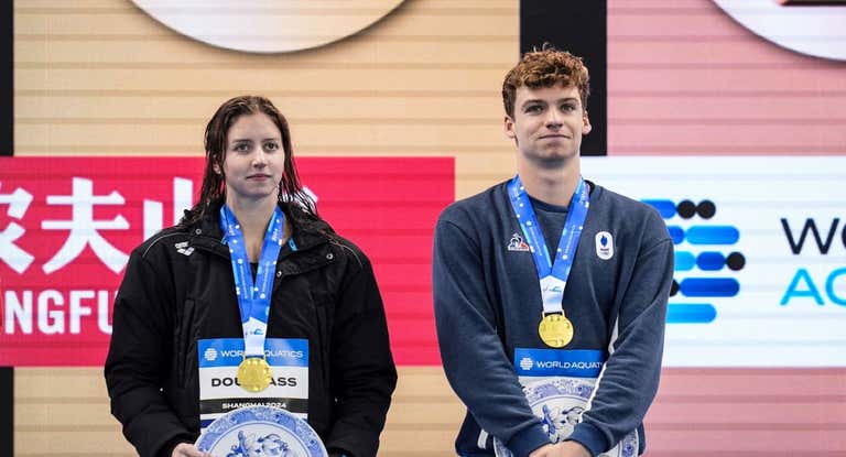 Kate Douglass junto a Léon Marchand en uno de los podios de la Copa del Mundo en Shanghai.