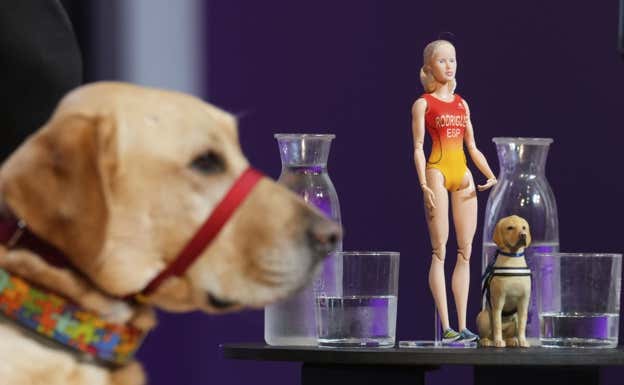 Yellow, el perro guía de Susana Rodríguez, y su representación en muñecos Barbie.  EFE