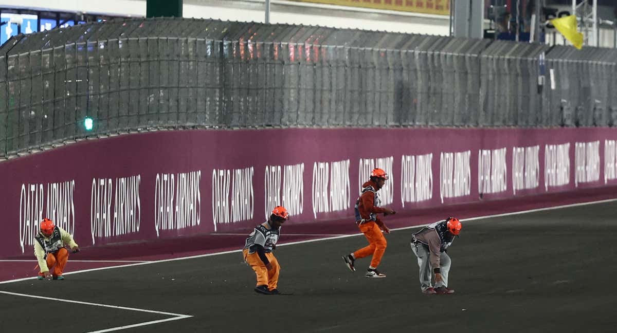 Los comisarios del circuito retiran los restos del retrovisor de Albon. /REUTERS/Jakub Porzycki