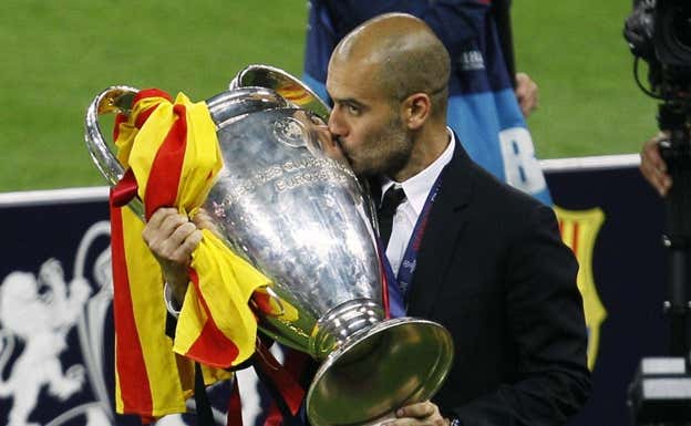 Guardiola besa la Champions que ganó con el Barça en 2011. AGENCIAS