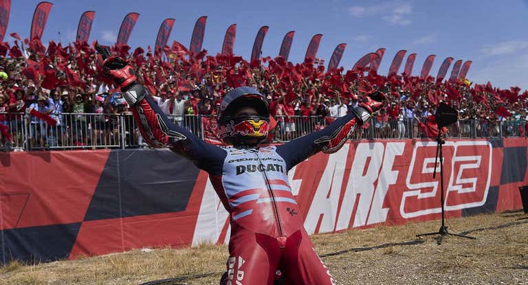 Marc Márquez celebra su victoria al lado de la grada del circuito de Aragón.