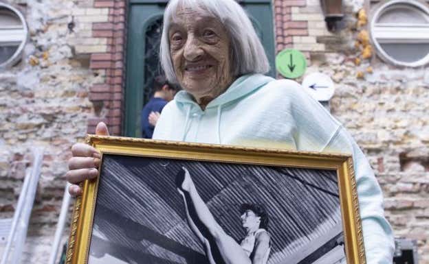 Agnes Keleti sujeta un cuadro con su foto de joven.  GETTY