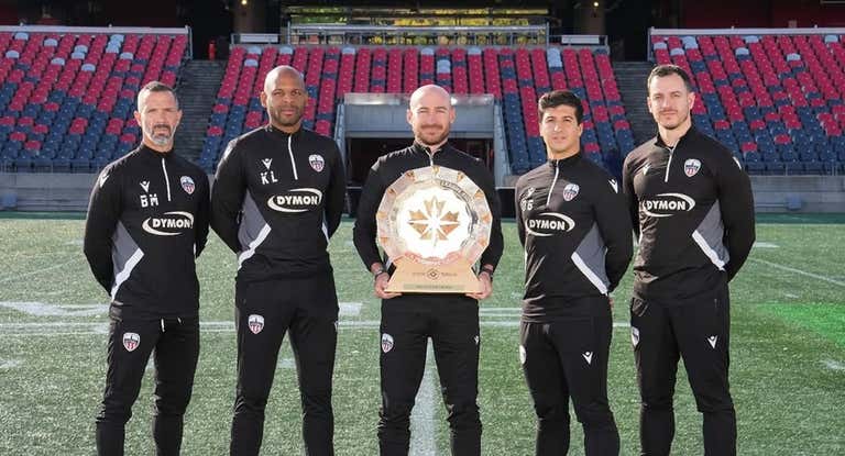 Carlos y parte de su staff con el título de campeón de Canadá.