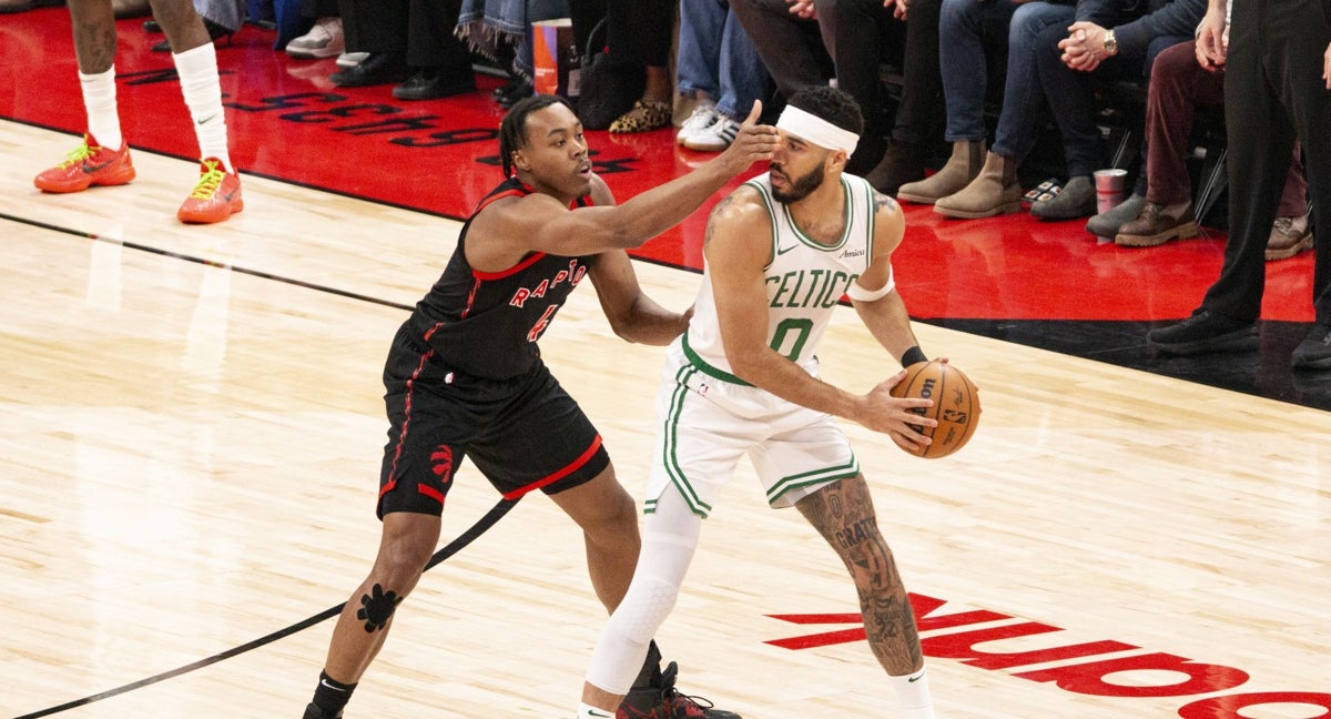 Scottie Barnes trata de frenar a Jayson Tatum.
