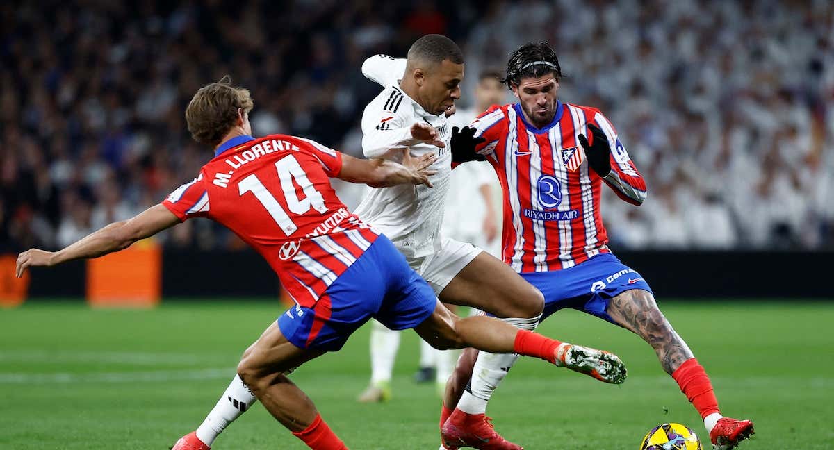 Kylian Mbappé pugna por el balón con Marcos Llorente y Rodrigo de Paul. /REUTERS