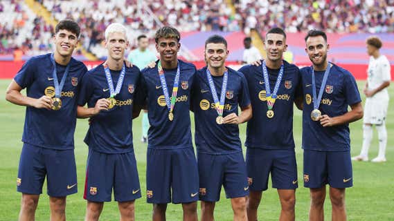 Los internacionales del Barça que fueron campeones este verano, muestran su medalla. /GETTY