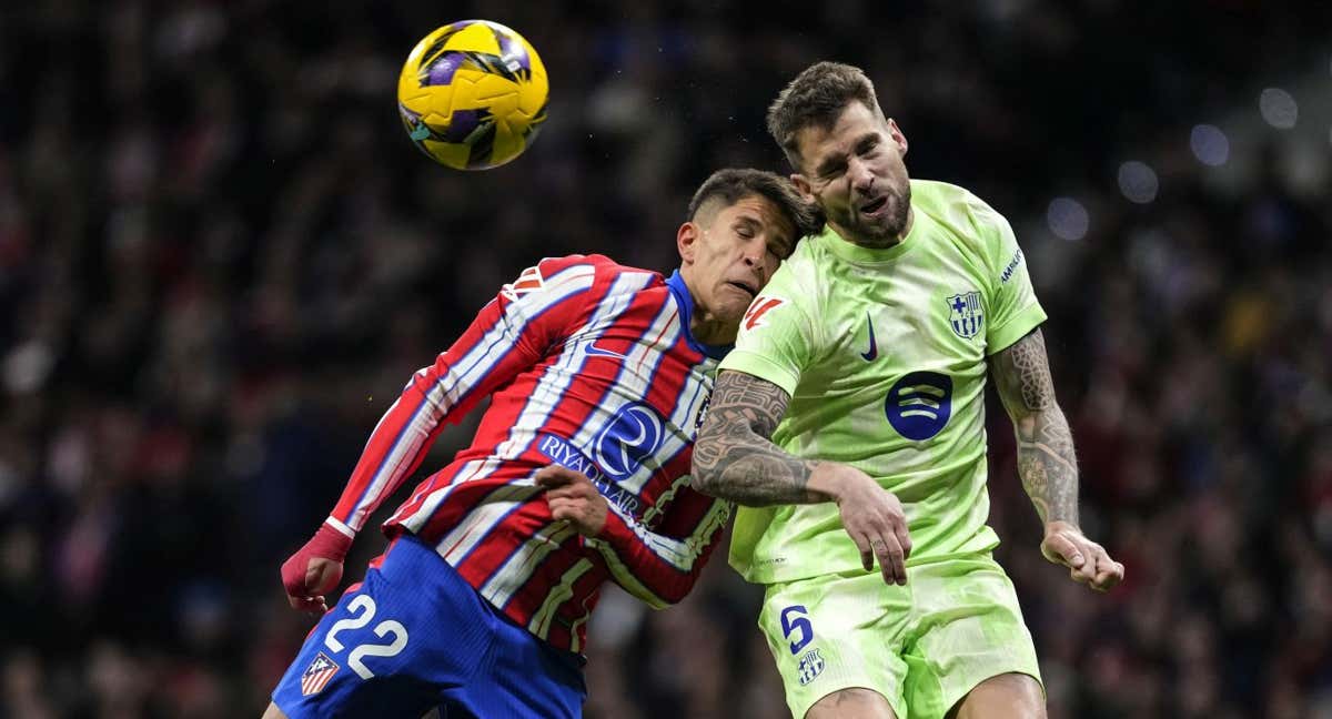 Íñigo Martínez pelea un balón con Simeone en el Atlético-Barcelona. /GETTY