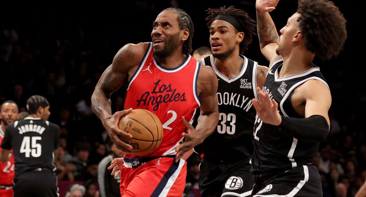 Kawhi Leonard intenta penetrar ente Nic Claxton y Jalen Wilson.