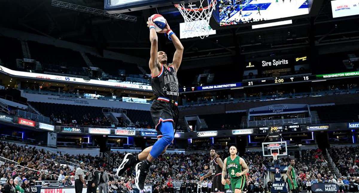 Un jugador de los Harlem Globetrotters se eleva para hacer un mate.