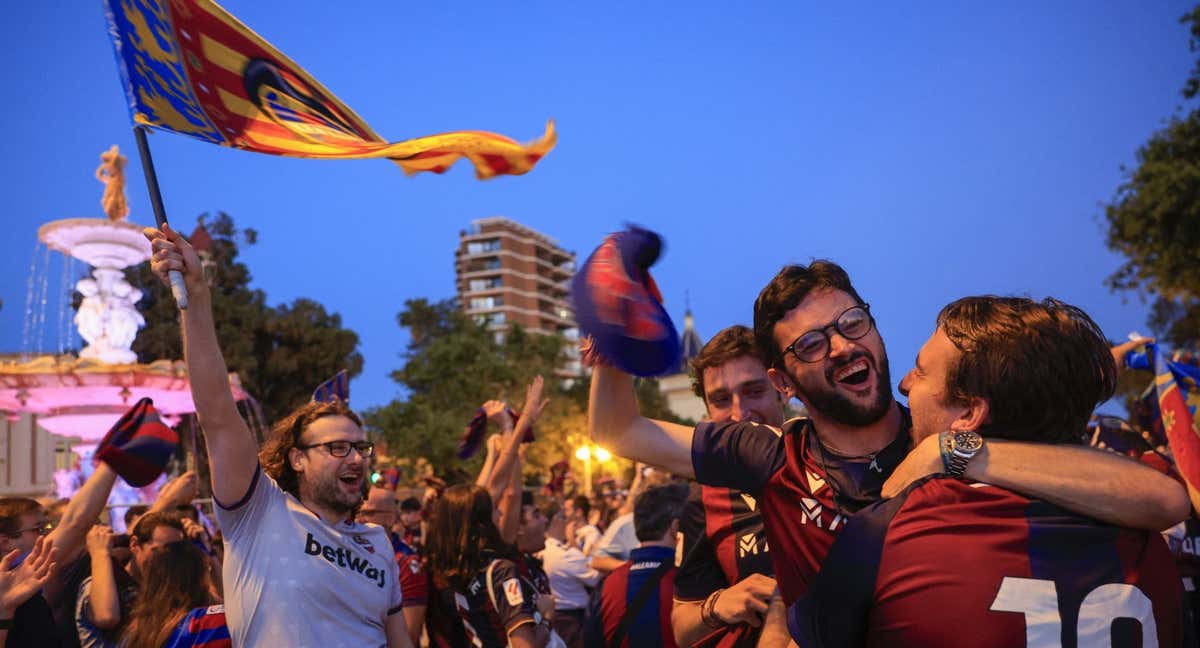 Aficionados del Levante celebran el ascenso de su equipo a Primera en la Fuente de las Cuatro Estaciones de Valencia./EFE/Kai Forsterling